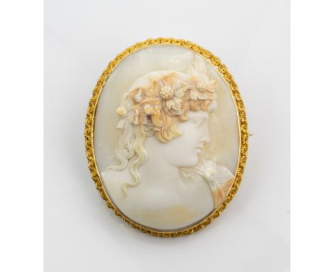 A large 18ct gold and shell cameo brooch, early 20th century, the cameo carved with a portrait of a classical beauty, within 