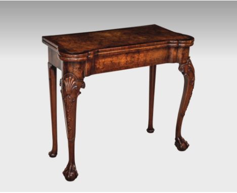 An early Georgian burr walnut card table, with concertina action, of rectangular form with shaped eared corners, the banded b