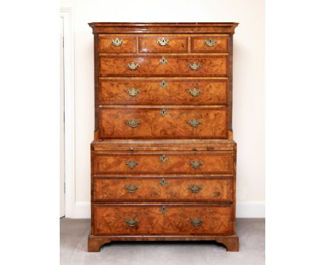 A George I walnut tallboy, with moulded cavetto cornice above three short and three long banded drawers inlaid with feather s