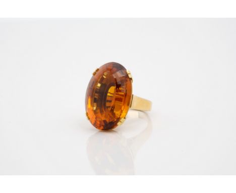 A 14ct yellow gold and citrine dress ring, the large, deep oval step cut citrine, approx. 25 x 17.5mm., four claw set over a 