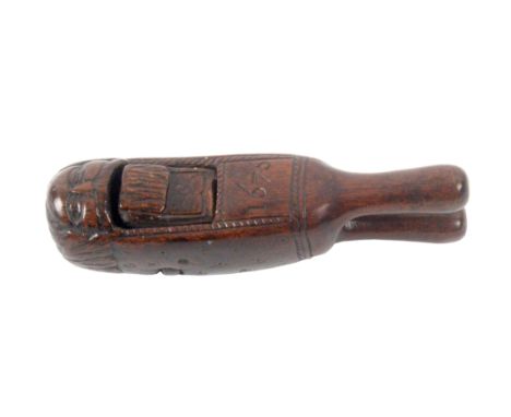 A fine Charles II figural nut cracker of scissor form dated '1676', carved as the head of a man with centrally parted hair an