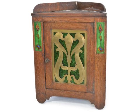 Arts &amp; Crafts corner cupboard with two rectangular tile inserts on either side of a textured green stained glass door beh