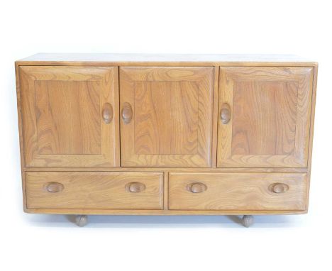 Ercol Elm Model 468 sideboard with triple doors revealing two sections and single cutlery drawer above two drawers, on orbit 
