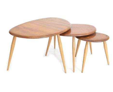 A nest of three Ercol 'pebble' tables, beech and elm, each raised on three turned splayed tapered legs, golden sticker - 1978