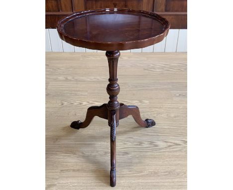 A reproduction Georgian mahogany tripod wine table, having a Chippendale style top with pie-crust edge, its cabriole legs hav