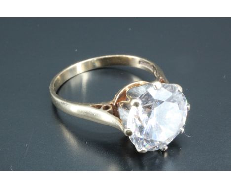 A large solitaire ring, having a white brilliant cut stone of approximately 3.5 carat, basket set between open chenier should