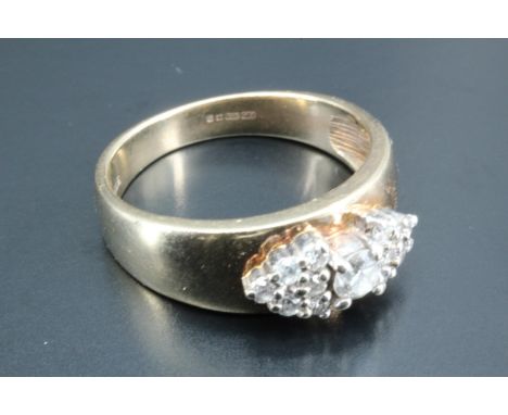 A lady's diamond ring, having a round brilliant diamond of approximately 0.12 carats between two adorsed trillion shaped clus