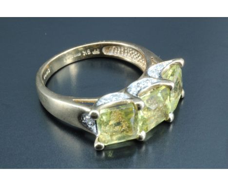 A contemporary three stone lady's dress ring, having a line of three yellow cushion cut square stones, 6 x 6 mm, the 9 carat 