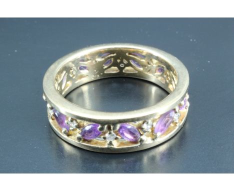 An unusual amethyst and diamond eternity ring, having navette shaped amethysts, approximately 2 x 4 mm, herringbone set betwe
