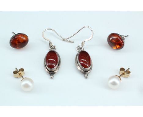 A pair of yellow metal mounted pearl stud earrings, (pearls 7 mm), together with two pairs of amber and white metal earrings
