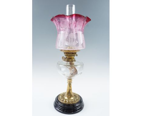 A Victorian oil lamp, having an Art Nouveau influenced etched achromatizing glass shade, a star-cut glass reservoir, brass co