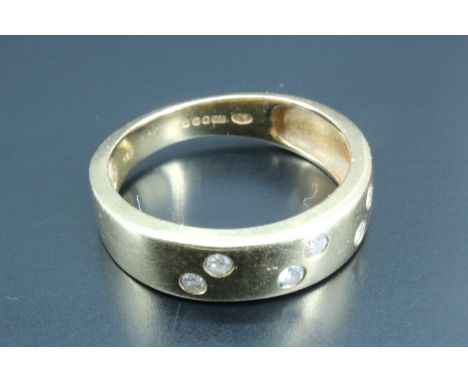 A lady's diamond ring, being an 18 carat gold band, tapering at the shoulders, having six offset pairs of small round gypsy s