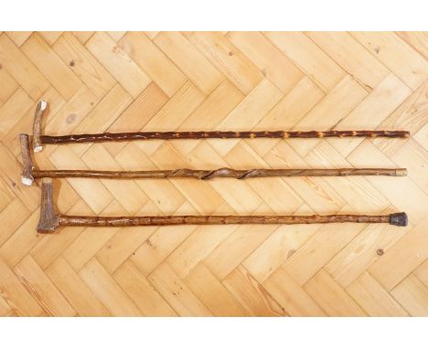 Two antler topped walking sticks, having twisted shafts together with a plain shafted antler topped stick, late 20th / early 