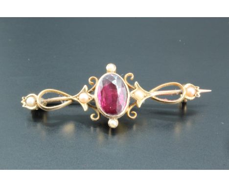 A late 19th / early 20th Century almandine and seed pearl openwork brooch, the oval facet-cut almandine of approximately 8 mm