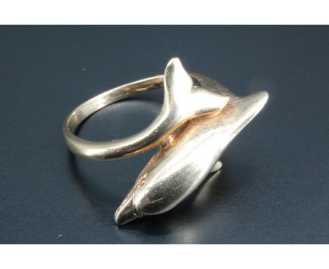 A lady's 9 ct gold dolphin finger ring, the shoulders morphing into a dolphin's body and tail respectively, as if wrapped aro