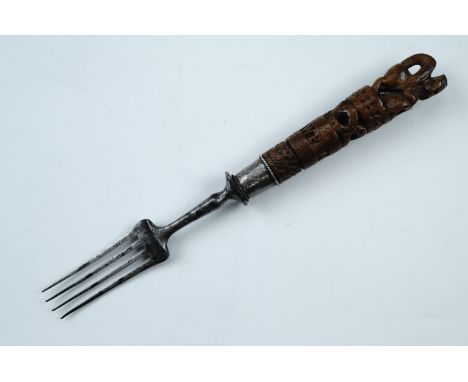 A 19th Century steel fork having a carved wooden handle and white metal collar, the handle having lion terminal and dated 187