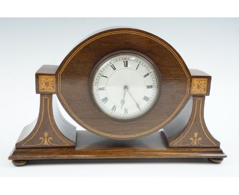 An Edwardian marquetry and string-inlaid mahogany mantle clock, having a French spring-driven movement with convex enamelled 