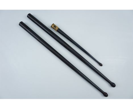 A pair of ebony drum sticks together with a small grenadier guards stick