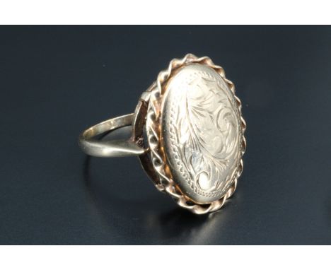 A 9 carat gold locket ring, the table being a bright cut oval surrounded by a rope twist border, 22 x 17 mm, hinged at one si