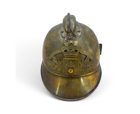 A French 1895 pattern brass fire brigade helmet, embossed and applied with flaming grenade device and motto.
