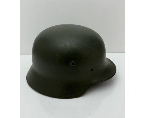 WWII German M35 steel army combat helmet shell. Marked ET64 to side inner rim and 3001 to back inner rim. Repainted apple gre