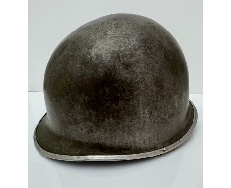 A WWII US military McCord made steel combat helmet shell, fixed bales and front seam. Marked ?077 068? to inner rim.  With re