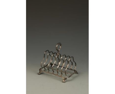 PAUL STORR: A WILLIAM IV TOAST RACK of seven shaped bars and a central leaf capped carrying handle, on downswept scroll feet,