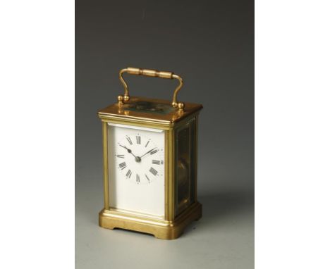 A FRENCH BRASS CASED STRIKING CARRIAGE CLOCK, the white enamel dial with Roman numerals, striking on a coiled gong, in a plai