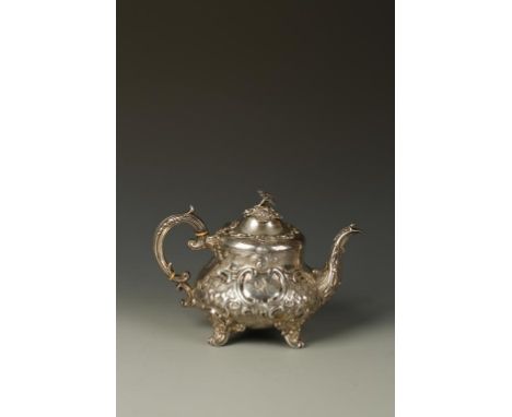 A VICTORIAN TEAPOT of circular bellied form with flower finial and leaf capped scroll handle, the body profusely embossed wit