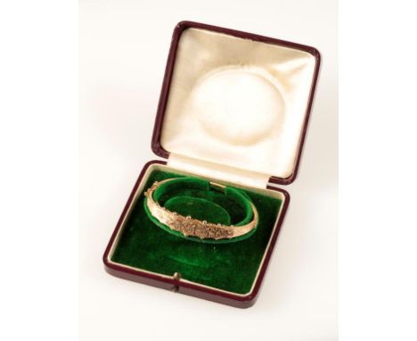 A VICTORIAN GOLD BANGLE, with engraved decoration, and saftey chain, in a fitted presentation case. See illustration