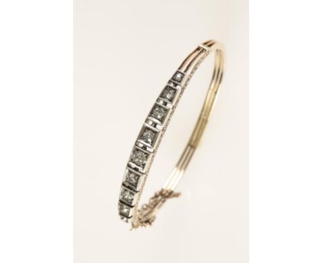 A DIAMOND-SET BANGLE comprising nine graduating old-cut claw-set diamonds, c.1.15cts (total weight), each diamond set in a wh