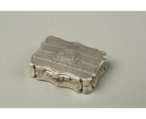 A VICTORIAN VINAIGRETTE of shaped rectangular form with geometric engine-turned decoration, monogrammed cartouche and gilt in