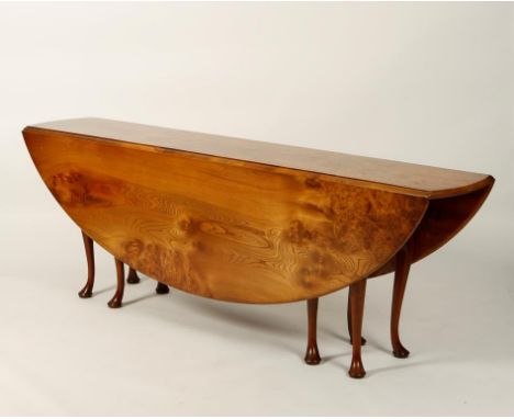 STUART LINFORD: A BESPOKE BURR ELM WAKE TABLE, the broad top with twin drop flap sides, on eight cabriole legs with pad feet,