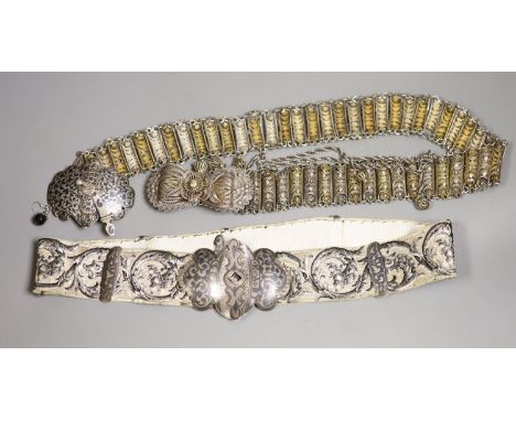   A white metal and niello belt buckle, one other on a sash belt and a filigree white metal belt.