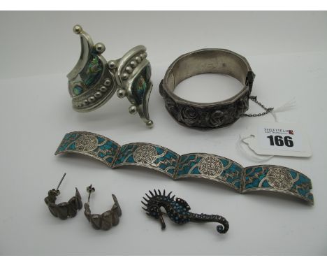 A Portuguese 'Topazio' Hinged Bangle, detailed in relief with roses, hinged to snap clasp; A Mexican Curved Panel Bracelet, s