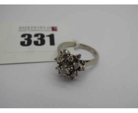 A Cluster Dress Ring, high claw set, stamped "18ct" (finger size K) (4.2grams). 