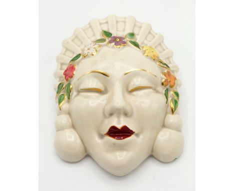 A Clarice Cliff wall pocket, Marlene, circa 1937, modelled as a female face with ornate head dress and earrings, adorned with