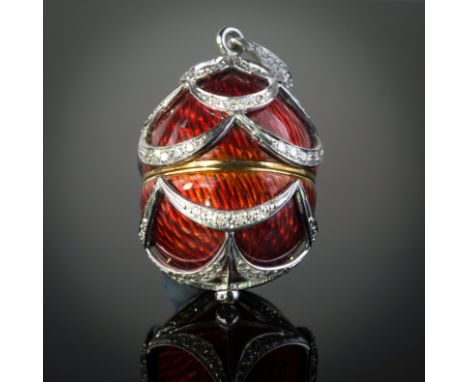 An 18ct white and yellow gold, enamel and diamond set egg pendant locket, the red enamelled egg with diamond set swagged deco
