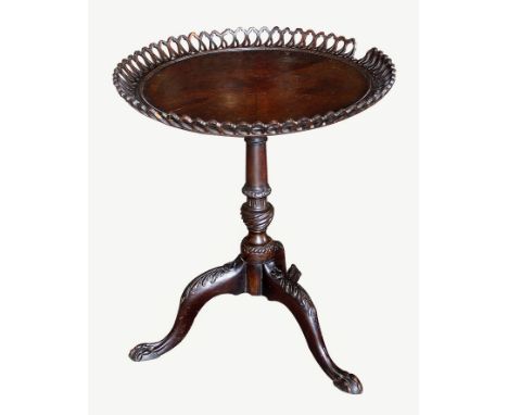 A 19th century mahogany tilt top tripod table, the circular top with flared and pierced gallery, on ring turned flared column