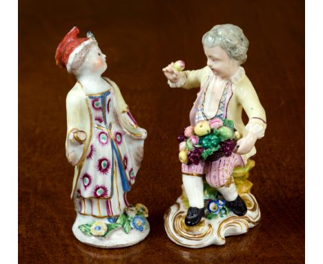 An 18th century English porcelain figure, possibly Bow, depicting a girl in yellow cloak over floral design dress, on circula