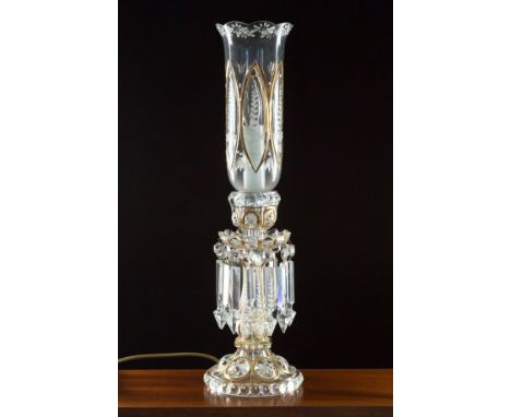 A Victorian style glass lustre table lamp, in the style of an oil lamp conversion, the moulded glass base and tulip form shad