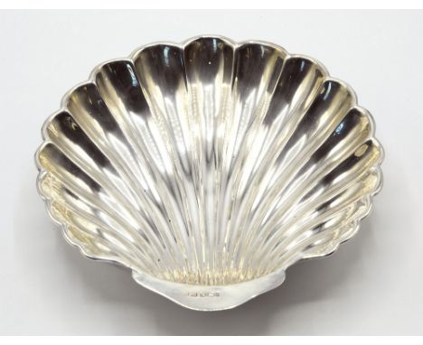 A late Victorian silver scallop shell dish, with ribbed decoration, standing on three ball feet, Sheffield 1901 by Harrison B