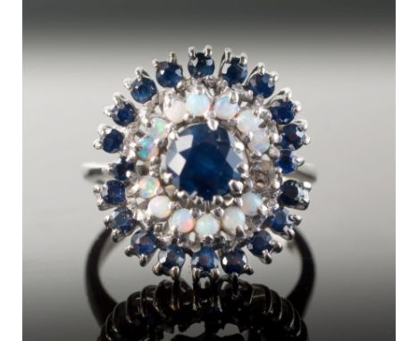 A vintage 18ct white gold, sapphire and opal cluster ring, the central round cut sapphire within double borders of small cabo