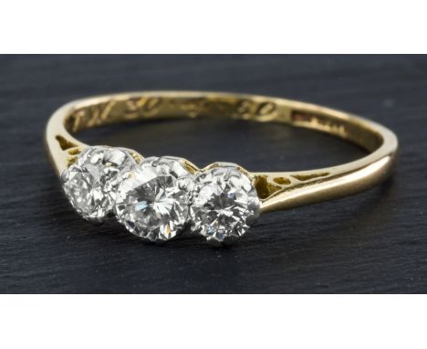 An 18ct gold, platinum and diamond three stone ring, mid-20th century, the three graduated brilliant cut diamonds totalling a