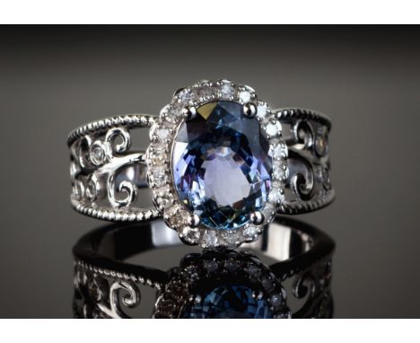 A 14ct white gold, Tanzanite and diamond cluster ring, the approx. 2.38ct oval cut Tanzanite bordered by twenty round cut dia