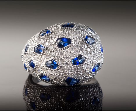 An 18ct white gold, sapphire and diamond bombe ring, the cabochon sapphires, total 2.18cts within pentagonal settings on a pa