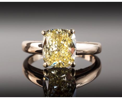 A fine natural yellow diamond single stone ring, the 3.00 carat cushion cut diamond, certificated as 'loupe clean', in a rose