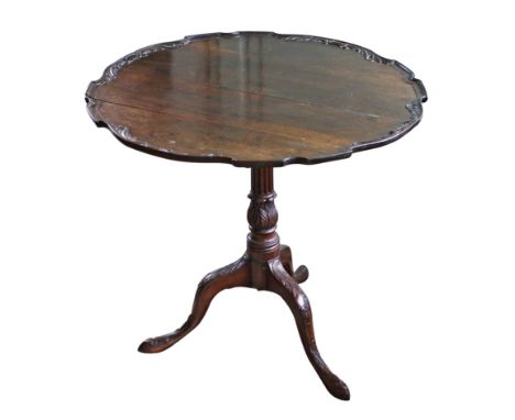 A George III mahogany piecrust tilt-top tripod table, foliate carved piecrust edge to the circular top, on fluted and foliate