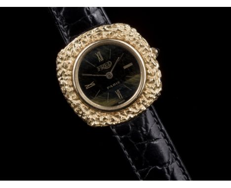 An 18ct gold cased ladies manual wind wrist watch by Fred of Paris, the circular 18.5mm. black and gold dial with gilt Roman 