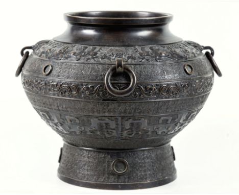 A Chinese antique bronze wine vessel, of p'ou form, contracted at the mouth with a plain rim, the body with taotie, flying ph